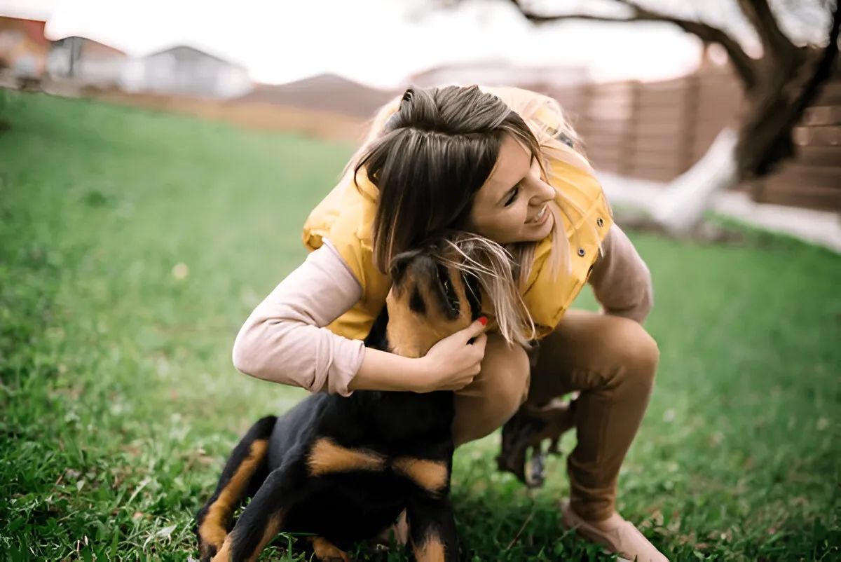 Woman hugging her puppy during their first puppy training session in Chicago, building trust and emotional connection in an outdoor setting.